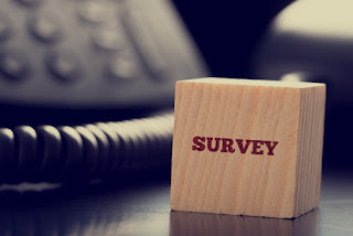 A wooden block stamped with the word "Survey" to emphasize that the best employee engagement surveys are customized