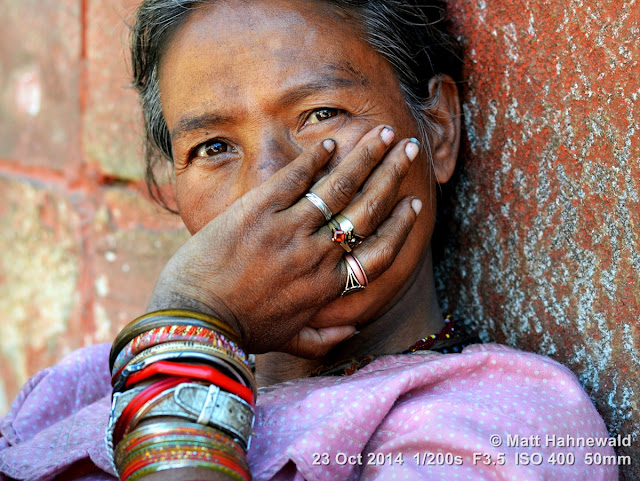 people, street portrait, headshot, face, eyes, Nepal, Kathmandu, beauty, Nepali lady, bangles, rings, eye contact, mouth guard gesture, dirty finger nails