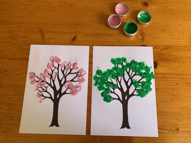 Two fingerprint tree pieces of artwork, with pink and green paint