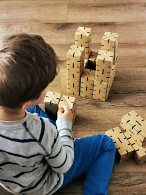 na zdjęciu dziecko budujące konstrukcję z klocków