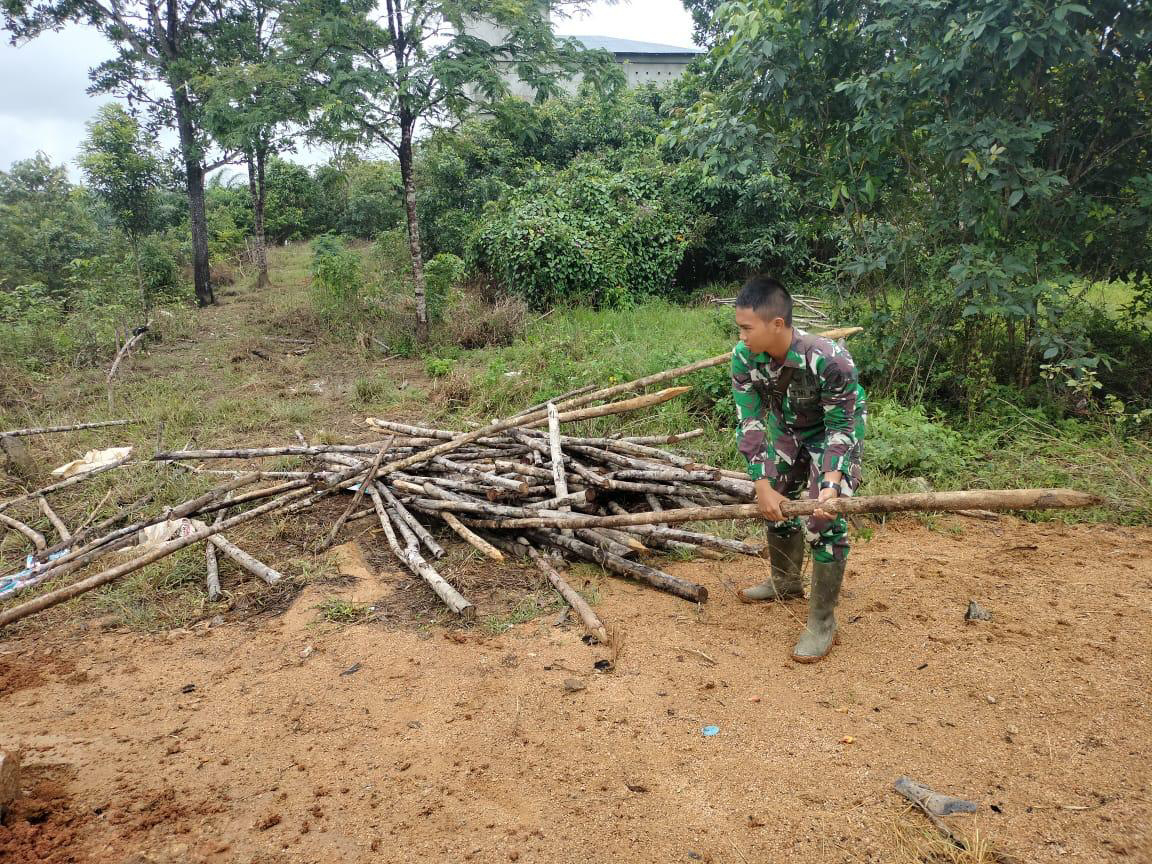 Anggota Satgas TMMD Menyiapkan Material Kayu