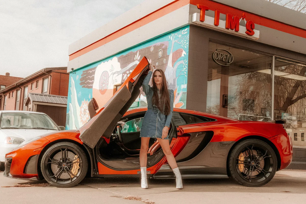 woman model in vintage clothing is posing close to the car