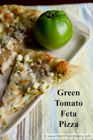 This vegetarian pizza showcases green tomatoes at their finest--topped with feta and mozzarella cheese on a garlic scape pesto-spread crust.