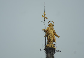 Gold statue rooftop Duomo Cathedral Milan, Italy