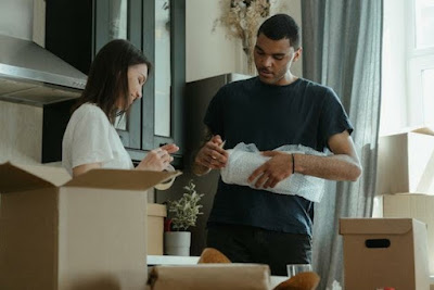 A couple packing their belongings in the boxes, thus showing you how packing for your New Jersey move is done.