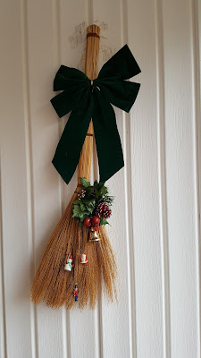 broom decorated for Xmas with bows and bells