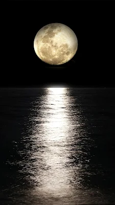 Bulan dan bayangannya di atas danau yang estetik di malam hari.