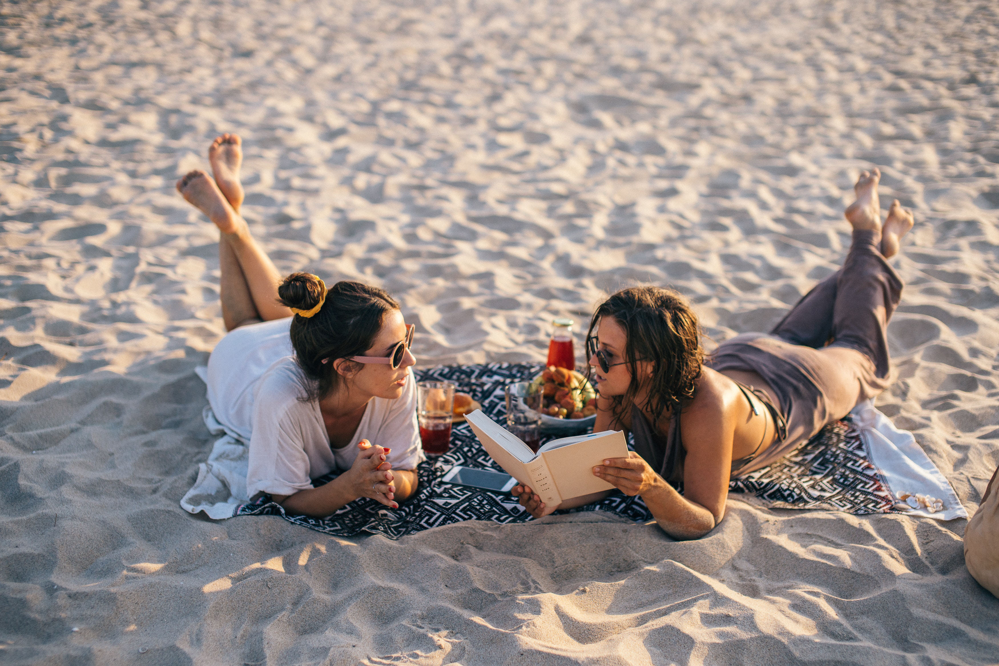 Women reading a book on the beach. Photo by Anna Tarazevich at Pexels