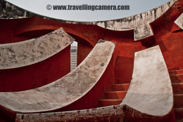 Some Experiments with old architecture of Jantar Mantar in Delhi, INDIA : Posted by VJ SHARMA on www.travellingcamera.com : Last month me and one of my friend were waiting for other folks to reach Connaught Place in Delhi and they called us to inform that all of them are arriving after 1:30 Hrs... This was good opportunity for us to explore some place nearby and decided to visit Jantar Mantar... After reaching the place I was not able to decide what should I shoot... Everywhere people were roaming and it was really difficult to find a place without people... and it was not like two or three folks.. It was huge crowd in front of each yantra @ Jantar Mantar.. So finally I decided to have some photographs which can avoid this crowd and it gave a good opportunity to place with various angles/compositions... check out and critics are welcome !!The first photograph where I wanted to have darkest possible shadows to make it look like black tiles in contact with reds and white ones.. Although it doesn't look like that... I would have to wait to click this photograph at right time but we had to move out in few hrs... Never mind, I will try it again...This time I was carrying SONY Alpha-700 and was confused with some of the controls.. Anyway that's not important... These yantras were very narrow is shape and it was difficult to fit myself for clicking these architecture forms nicely... Here is a tilted view of a semi-spherical yantra @ Jantar Mantar...All these photographs from the same yantra and it was was quite interesting... But please don't ask me about how it functions and what it is supposed to do...Stairs hidden behind these structures and everyone needs to follow them to go down and see the real work inside these yantras.. In Jantar Mantar at jaipur, everyone was not allowed to go inside these structures but in Delhi I didn't see such restrictions except one which had highest structure followed by lot of stairs....Jantar Mantar in Delhi is a very popular place among activists, social associations and artists as well... Many of the NGOs choose this place to start a rally or protest... Also many artists have explored this very well and many times Photographers have exhibited this place...A Series of small pillars taking all the weight of small paths connecting outer circle of a structure with a pole in the middle... as you can see the turning path in a circle...One of my friend called it 'Stairs of Success'.. I don't if that is the name of these stairs but like the caption :)Final Photograph showing the close-up view of this architecture which shows the age of this structure and its been repaired multiple times in past which resulted in this roughness... I am again planning to visit Jantar Mantar in Delhi and will ensure that I get full day to spend there...