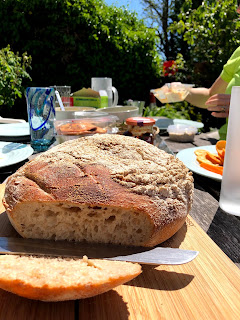 A loaf of sourdough bread on a table in a garden