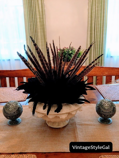 Urn styled on dining room table with vintage looking objects on table