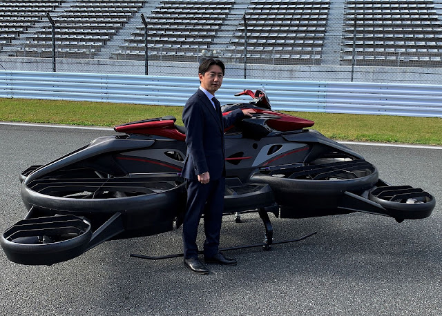 Daisuke Katano ผู้บริหารระดับสูงของ ALI Technologies ยืนเคียงข้าง Xturismo Limited Edition ภาพ: รอยเตอร์