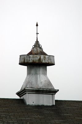 this is a dull photo of a grey barn cupola at Hancock Shaker Village, made worse by a washed-out grey sky