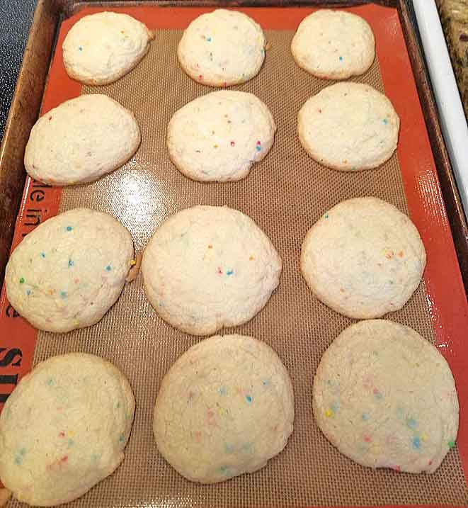 sugar cookies cooling on a cookie sheet