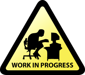 This is a picture of a triangular sign with a person in front of a computer that says work in progress.