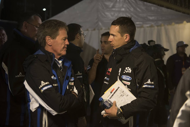 Co-driver Julien Ingrassia talking to M-Sport's Malcolm Wilson