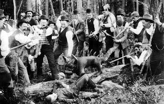 black and white image from 1893 of a group of men surrounding a hodag