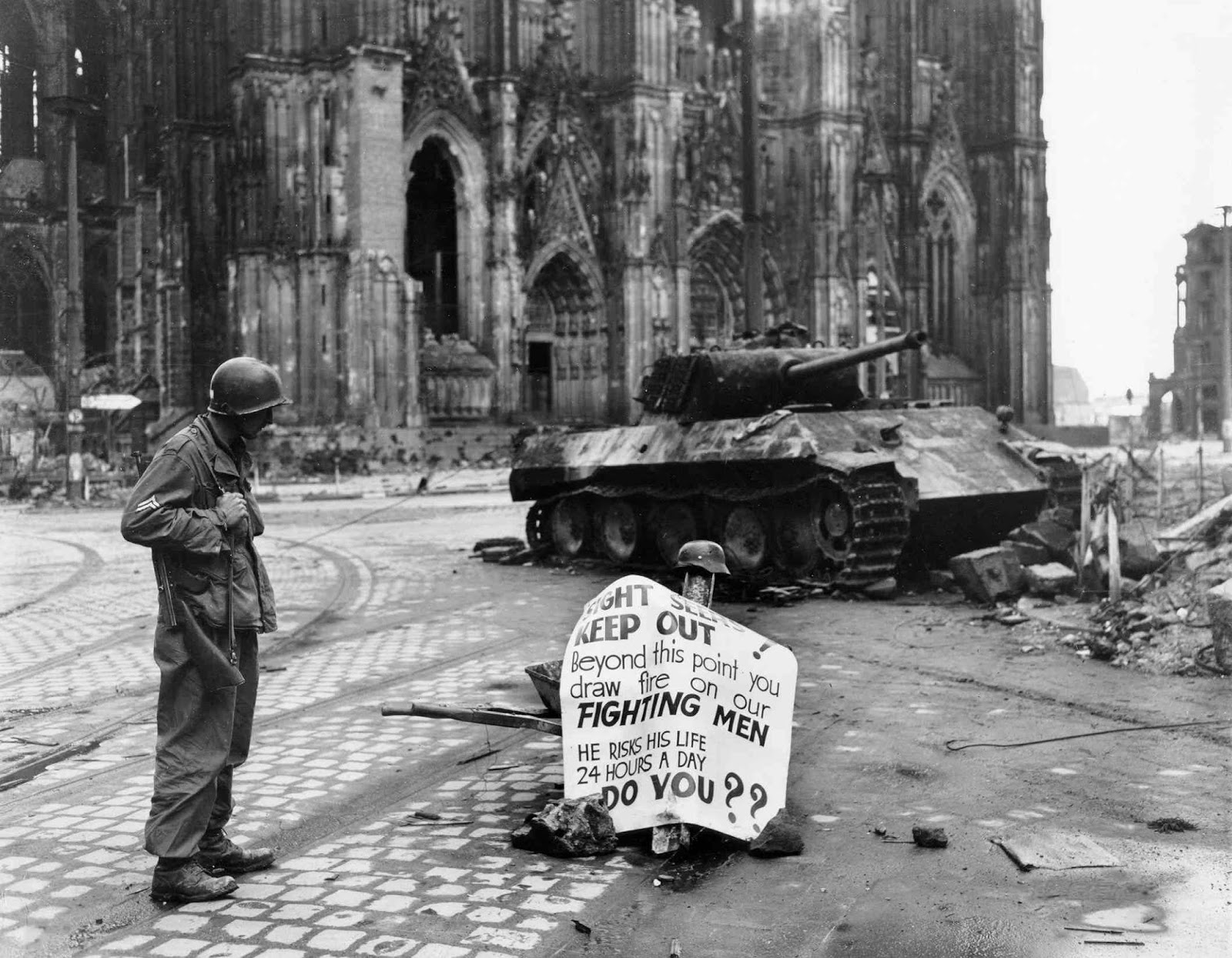 40 Unbelievable Historical Photos - Corporal Luther E. Boger of US 82nd Airborne Division reading a warning sign, Cologne, Germany, 4th April 1945.