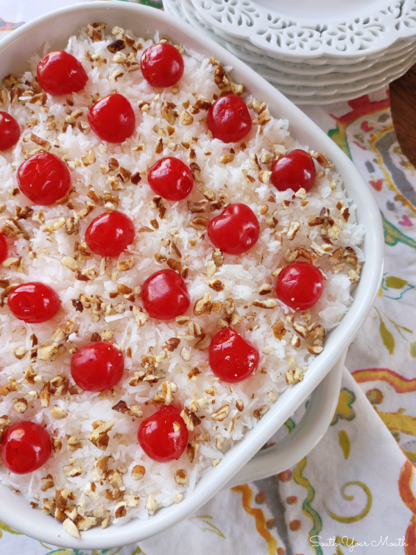 Italian Bakeless Cake! A layered no-bake dessert with vanilla wafers and creamy pineapple “pudding” made with sweetened condensed milk and lemon juice topped with cool whip, coconut, cherries and pecans.