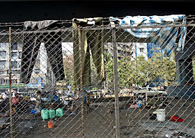 slum dwellers clothes hanging out to dry on a fence