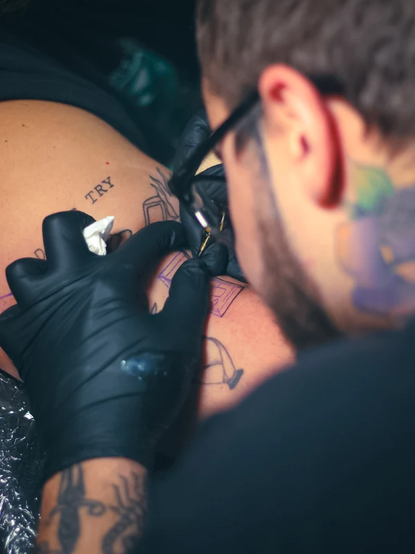 man getting a tattoo on his leg