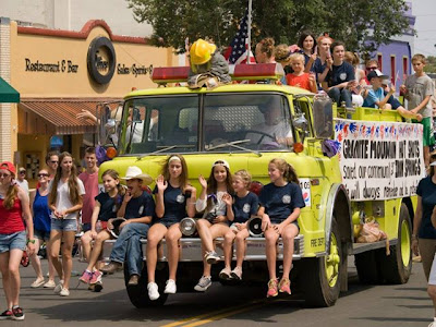 There are many kids and teenagers join in the Prairie pioneer days parade and follow the fire trucks.