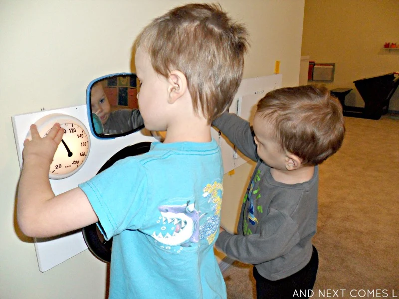 Playing with a DIY upcycled car dashboard sensory board for kids from And Next Comes L