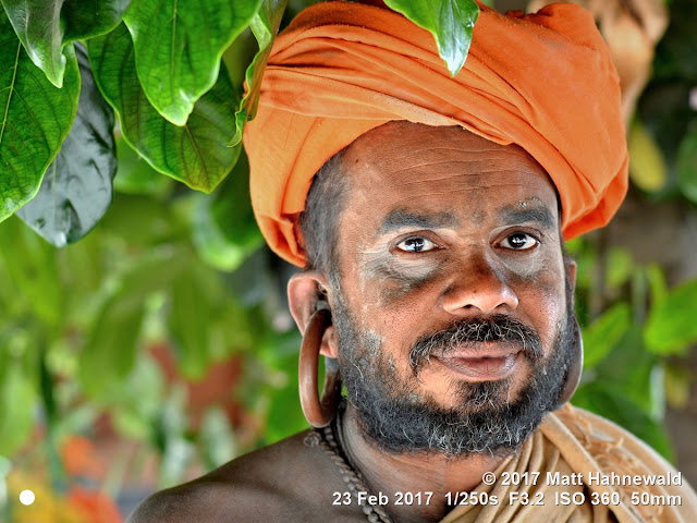 matt hahnewald photography; facing the world; gorakh nath; monk; monastery; bhavnath; bhavnath fair; character; face; earrings; ears; holed; eyes; facial expression; eye contact; full beard; turban; orange; consent; empathy; rapport; respect; traveling; religious; traditional; cultural; hinduism; festival; event; mela; devotee; pilgrim; junagadh; gujarat; asian; indian; western india; one person; male; middle-aged; man; picture; photo; face perception; physiognomy; educational; nikon d3100; nikkor af-s 50mm f/1.8g; prime lens; 50mm lens; 4x3 aspect ratio; horizontal orientation; street; portrait; closeup; headshot; seven-eighths view; outdoors; color; posing; authentic; smiling; powerful; kanphata; yogi; darshani; gorakhnathi; shaivism; big; splitted ears