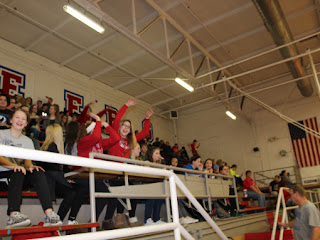 Students in the bleachers in the gym cheering