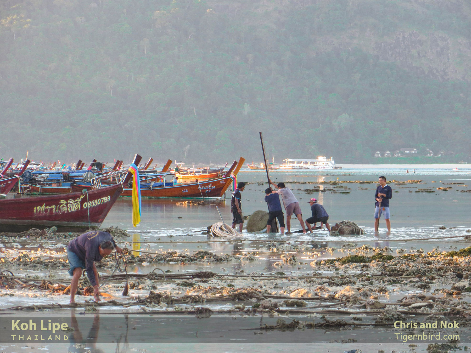 Islanders anchoring mooring line at low tide in Koh Lipe