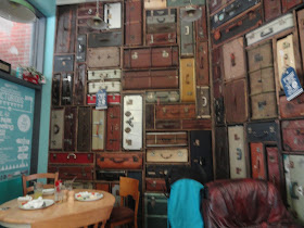 wall made of suitcases and trunks, stacked up, in a cafe in Chichester