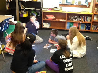 Students sitting on the floor discussing books