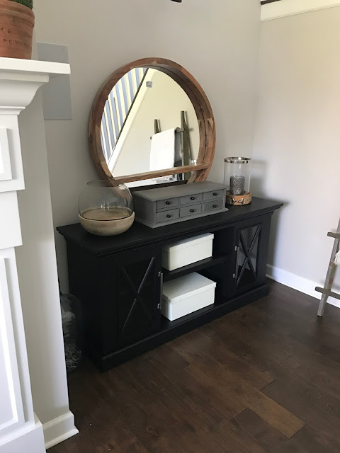 Round mirror above TV console