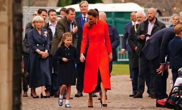 Kate Middleton wore a long red coat. Princess Charlotte wore a navy frock coat by AmaiaKids Razorbil and blue Mary Jane shoes