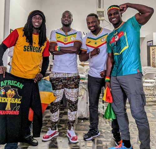 Four fans flex for the camera in their Sénégal clothes