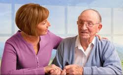 An elderly male patient being attended by a young woman