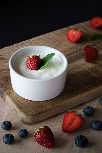 Yogurt in bowl on wooden table with scattered berries:Photo by Tiard Schulz on Unsplash