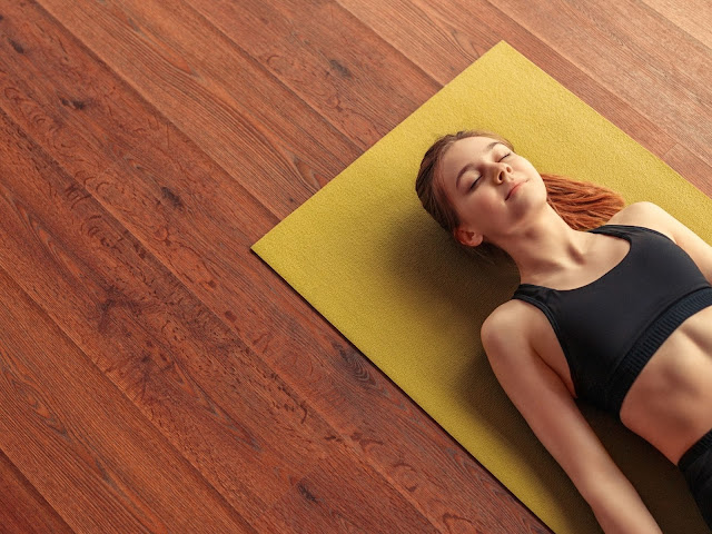 woman-meditating-lying-down-on-a-yoga-mat