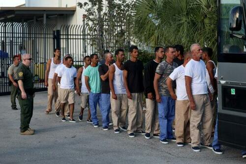 Illegal aliens from Cuba line up to board a bus to be driven to a U.S. Customs and Border Protection station as they are processed in Marathon, Fla., on Jan. 5, 2023