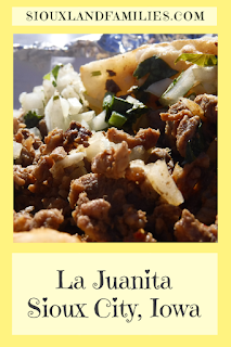 a yellow rectangle shows a steak taco topped with onions and cilantro and the words "La Juanita Sioux City, Iowa" on the bottom and "SiouxlandFamilies.com" at the top, smaller.