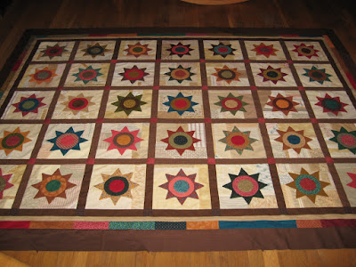 quilt with applique stars on scrappy backgrounds