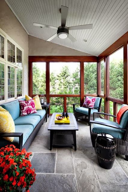 contemporary living room for the family with vibrant pops of colors, large floor to ceiling windows, and rustic stone floor