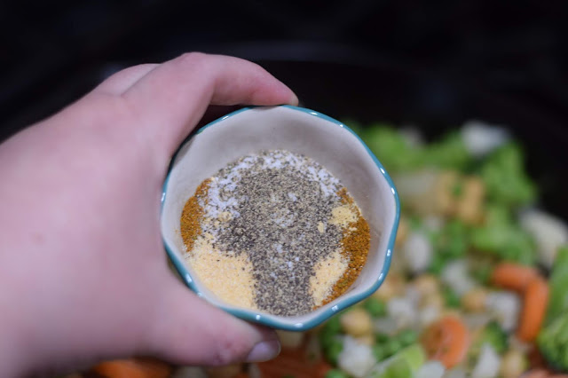 The spices being added to the skillet with the vegetables and chickpeas. 