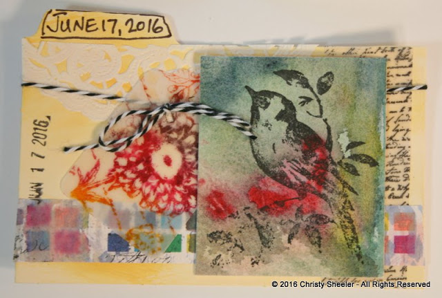 ICAD June 17, A collage on pale yellow gesso and watercolor background.  Stamped script, flower and bird.