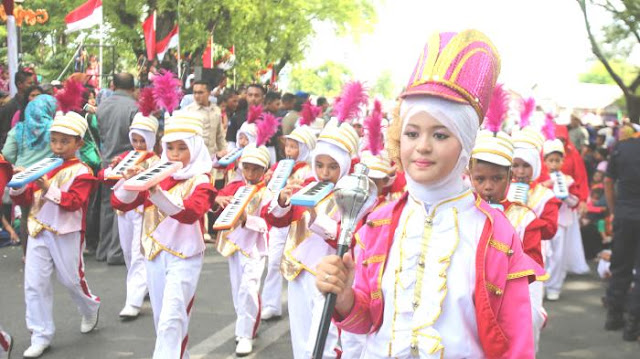 Rayakan kemerdekaan dengan pawai.