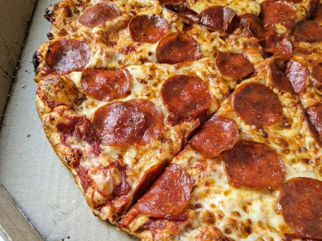 A close-up of Domino's Extra Large Pepperoni New York Style Pizza.