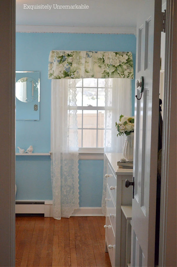Blue Cottage Style Bedroom with white lace curtains and floral valance