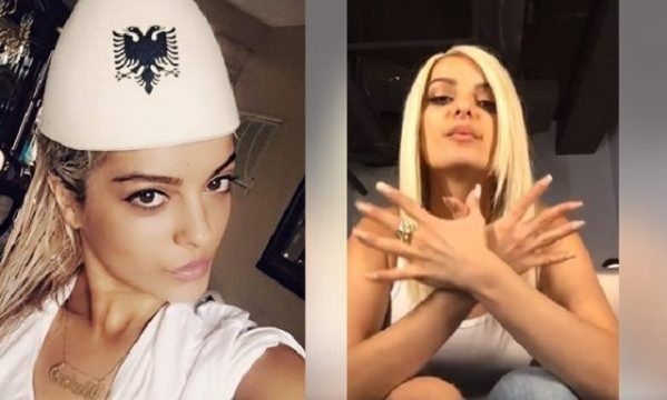 Bebe Rexha wearing a traditional Albanian hat and performing the Albanian eagle symbol with her hands