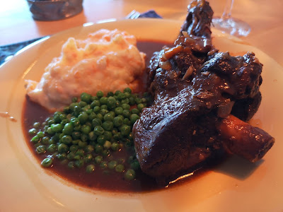 Lamb shank with potato-carrot mash and baby peas