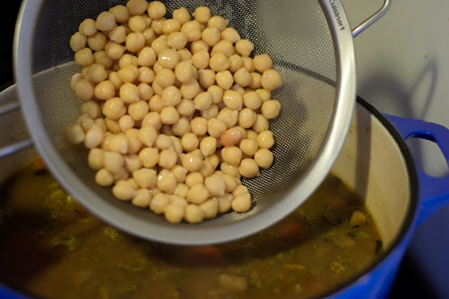 Chickpeas being added to the pot.